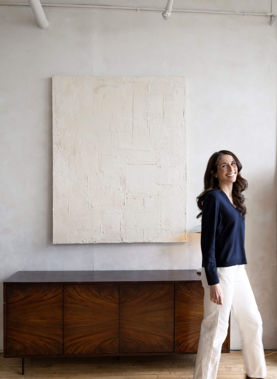 Kathryn Ressa, smiling walking across the room.